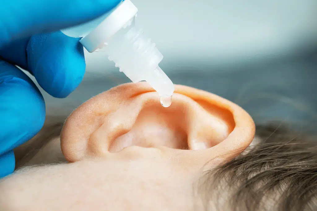 Child cleaning ears with peroxide